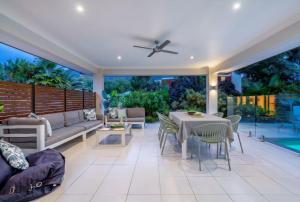 a patio with a couch and a table and chairs at Belle Escapes Sandcastles in Palm Cove