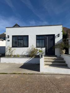 a white house with a black door at One bedroom flat in Pevensey Bay in Pevensey
