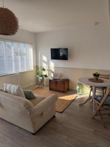 a living room with a couch and a table at One bedroom flat in Pevensey Bay in Pevensey