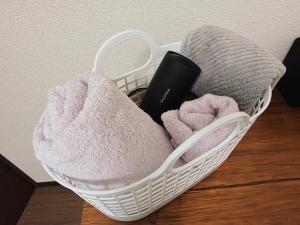 a basket filled with towels on a wooden floor at Oyado SORARURI in Yakushima +28 photos