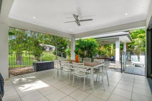 a dining room with a table and chairs on a patio at Belle Escapes Castaways in Palm Cove