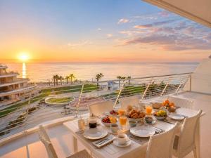 a table with food on a balcony with a view of the ocean at Infinity View Penthouses by NRAS in Arenales del Sol
