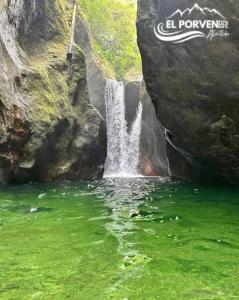 a waterfall on the side of a mountain with green water at Piñas Room in El Pino