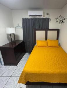 a bedroom with a yellow bed and a desk at Piñas Room in El Pino