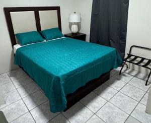 a bedroom with a bed with a green bedspread at Piñas Room in El Pino