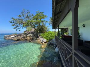 a house with a balcony overlooking the ocean at Minang Cove Resort in Tioman Island