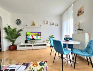 a living room with a tv and a table and chairs at Zafir Luxory in Kaposvár