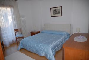 a bedroom with a blue bed and a wooden table at Love & Live Pinè in Baselga di Pinè