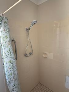 a bathroom with a shower with a shower curtain at Good price Apartment self check-in in Geraldton +11 photos