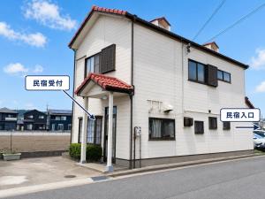 a white building with two street signs on it at 晴の川 in Wakayama