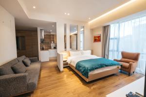 a bedroom with a bed and a couch at May Seven Hotel and Suites in Ulaanbaatar