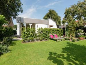 two pink chairs sitting on a lawn in a yard at Alluring Apartment in Bergen with Terrace, Garden and BBQ in Bergen
