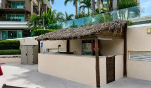 a bar with a straw roof on a building at Grand Venetian Comfort in Puerto Vallarta