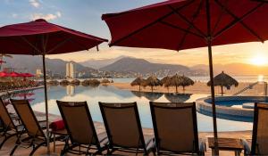 a group of chairs and umbrellas on a beach at Grand Venetian Comfort in Puerto Vallarta