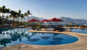 a pool at a resort with chairs and umbrellas at Grand Venetian Comfort in Puerto Vallarta +143 photos