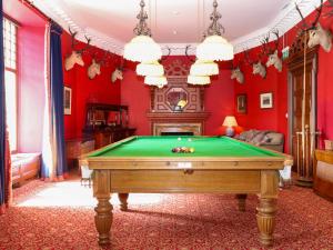 a pool table in a room with red walls at Paye House - Cromarty in Cromarty