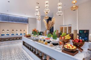 a buffet line with bowls of fruits and vegetables at Novotel Living Hangzhou International Convention Center in Hangzhou
