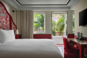 a bedroom with a bed and a desk and a window at Maxwell Reserve Singapore, Autograph Collection in Singapore +84 photos