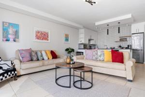 a living room with two couches and a table at Built on Hope De Waterkant in Cape Town