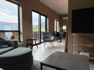 a living room with a couch and a flat screen tv at Aurora Apartments - Mountain View in Stryn