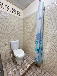 a bathroom with a toilet and a shower at Marlynto Surf Camp in Hilibotodane +51 photos
