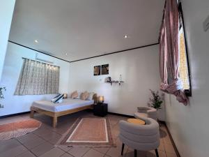 ein Wohnzimmer mit einem Bett und zwei Stühlen in der Unterkunft Cliffside Resort in Panglao + 85 Fotos