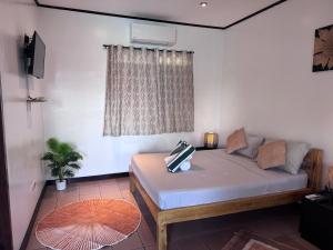 ein Schlafzimmer mit einem Bett in einem Zimmer mit Fenster in der Unterkunft Cliffside Resort in Panglao