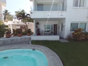 a swimming pool in front of a house at Condominio Los Corales in Manzanillo