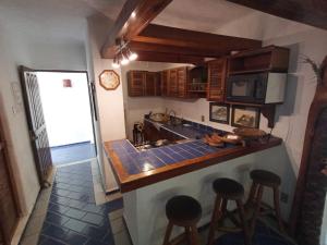 a kitchen with a counter and some stools in it at Condominio Los Corales in Manzanillo