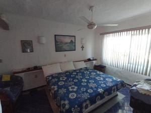 a bedroom with a bed and a ceiling fan at Condominio Los Corales in Manzanillo