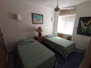 a hotel room with two beds and a window at Condominio Los Corales in Manzanillo