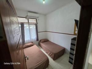a small room with two beds and a window at Omah Diaz Homestay Malioboro in Jetis
