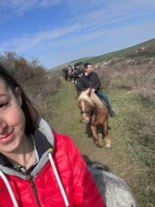 a group of people riding horses down a hill at Fancsali Lak in Ulcani