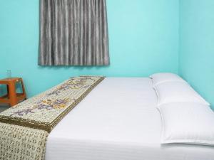 a bed in a blue room with a window at santosh lodge in Muzaffarpur