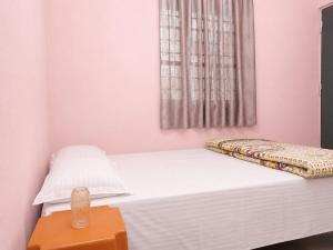 a bedroom with a white bed with a window at santosh lodge in Muzaffarpur