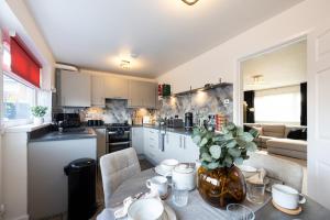 a kitchen with a table with a vase on it at Peaceful hideaway with homely comforts in Timperley