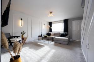 a living room with a couch and a table at Peaceful hideaway with homely comforts in Timperley
