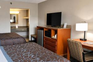 a hotel room with a bed and a flat screen tv at Days Inn by Wyndham Apple Valley Pigeon Forge/Sevierville in Pigeon Forge