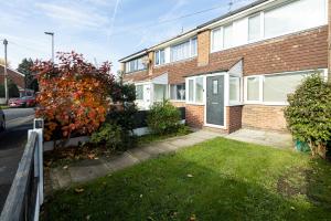 a brick house with a door and a yard at Peaceful hideaway with homely comforts in Timperley