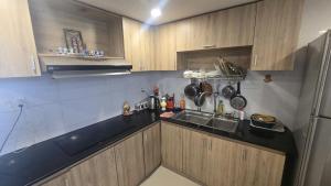 a small kitchen with a sink and a refrigerator at Chu's Hotel & Homestay in Xã Thang Tam