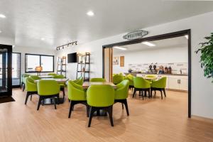 a dining room with green chairs and a table at Super 8 by Wyndham Montpelier - Bear Lake in Montpelier