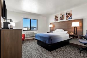 a hotel room with a bed and a desk and a chair at Super 8 by Wyndham Montpelier - Bear Lake in Montpelier +69 photos
