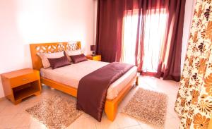 a bedroom with a bed and a large window at Mahdia Place Apartments in Mahdia