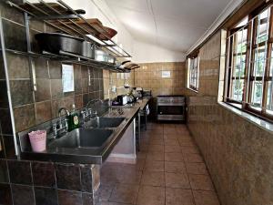 a large kitchen with two sinks and a stove at Forest Lodge - Richards Bay in Richards Bay