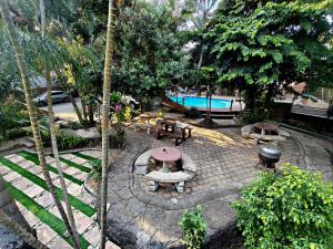 an outdoor patio with a table and benches and a pool at Forest Lodge - Richards Bay in Richards Bay