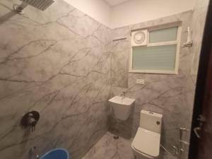 a bathroom with a white toilet and a window at Aagaminn-A Boutique Hotel in Kota