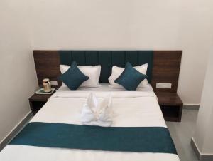 a bedroom with a large bed with blue and white pillows at Aagaminn-A Boutique Hotel in Kota