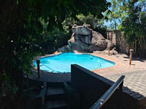 a swimming pool with a waterfall in a backyard at Forest Lodge - Richards Bay in Richards Bay