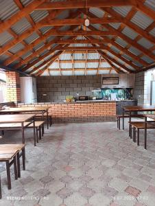 a large room with wooden tables and a kitchen at База отдыха Golden rest in Borovoye