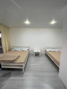 a room with two beds and a table at База отдыха Golden rest in Borovoye
